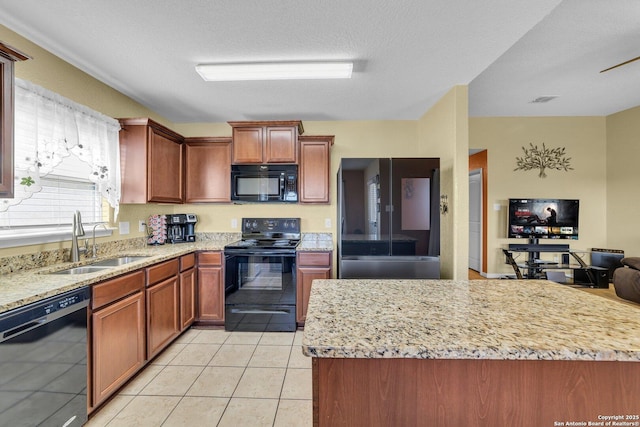 kitchen with light stone counters, light tile patterned floors, visible vents, a sink, and black appliances