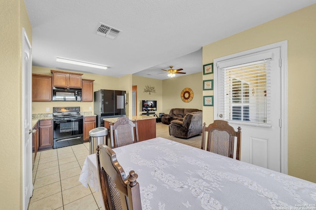 dining area featuring light tile patterned flooring, visible vents, and ceiling fan