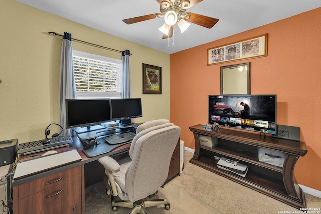 office space with light colored carpet, baseboards, and a ceiling fan