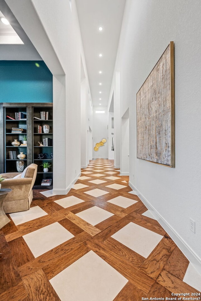 hallway featuring built in features, recessed lighting, and baseboards