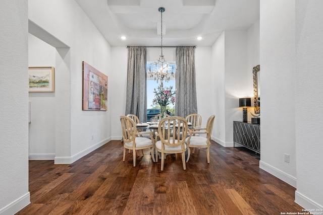 dining space featuring a chandelier, dark wood-type flooring, and baseboards