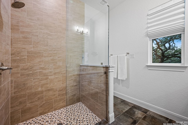 full bath featuring visible vents, baseboards, and tiled shower