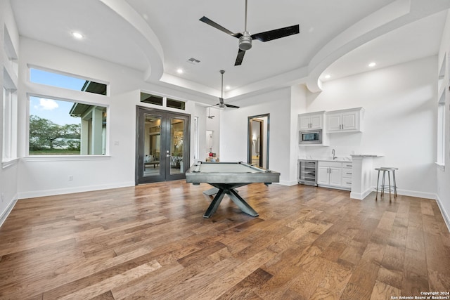 recreation room with wood finished floors, visible vents, a sink, wine cooler, and french doors