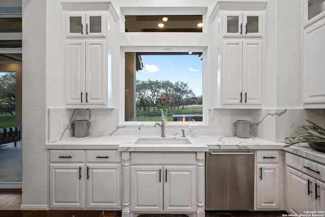 kitchen featuring dishwasher, white cabinetry, and a sink