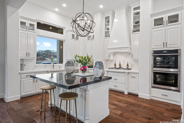 kitchen featuring white cabinets, stainless steel appliances, and premium range hood