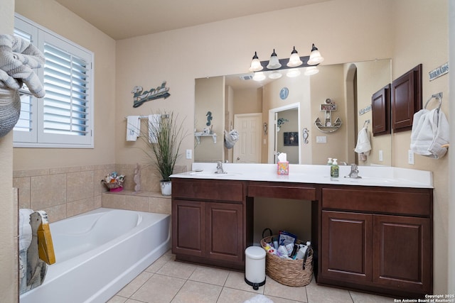 bathroom with tile patterned floors, a garden tub, double vanity, and a sink