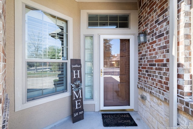 view of exterior entry featuring brick siding