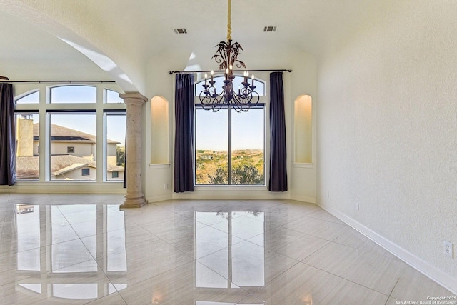 unfurnished dining area featuring visible vents, baseboards, decorative columns, an inviting chandelier, and arched walkways