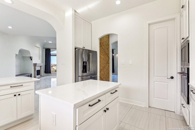 kitchen featuring white cabinetry, arched walkways, and appliances with stainless steel finishes