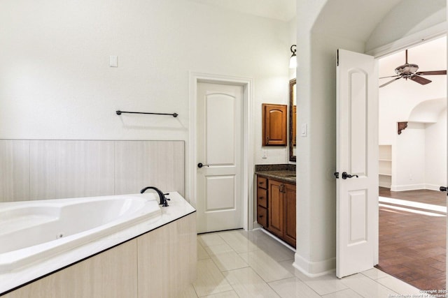 bathroom with wood finished floors, a garden tub, ceiling fan, and vanity