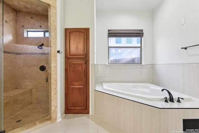 bathroom featuring tile patterned flooring, tiled shower, and a garden tub