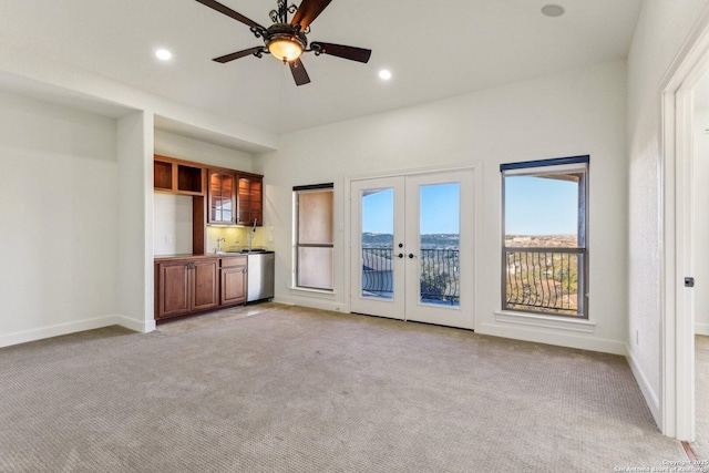 unfurnished living room featuring recessed lighting, french doors, light colored carpet, and baseboards