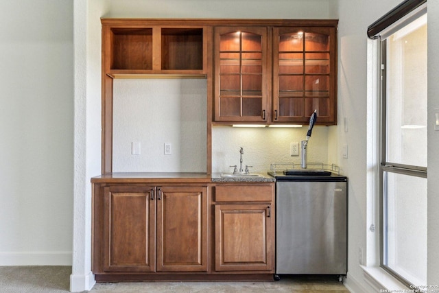 bar with a sink, baseboards, and refrigerator