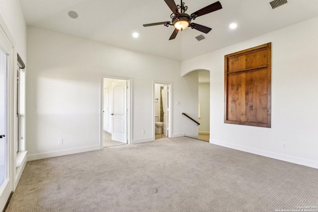 unfurnished bedroom with recessed lighting, visible vents, light carpet, and arched walkways