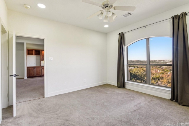 carpeted spare room with a ceiling fan, recessed lighting, visible vents, and baseboards