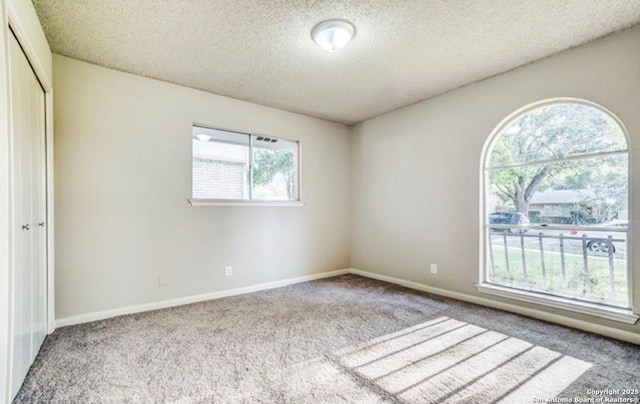 unfurnished bedroom featuring a textured ceiling, carpet, a closet, and baseboards