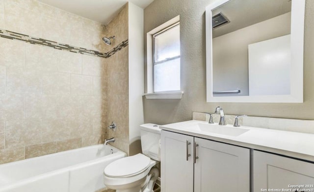 bathroom featuring visible vents, toilet, a textured wall, vanity, and  shower combination