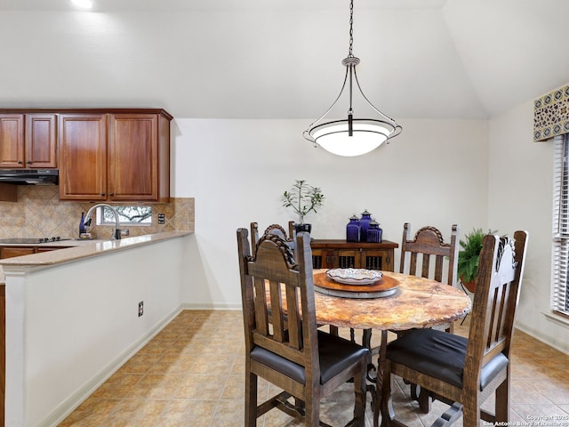 dining room with light tile patterned floors, baseboards, and lofted ceiling