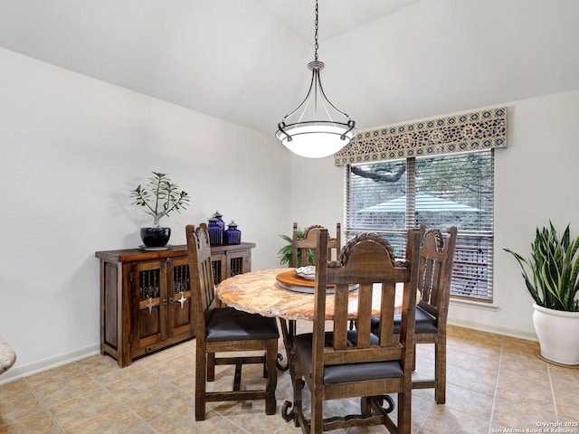 dining area featuring lofted ceiling, light tile patterned floors, and baseboards