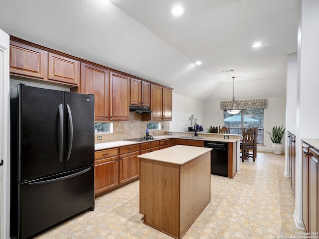 kitchen with a peninsula, black appliances, vaulted ceiling, light countertops, and under cabinet range hood