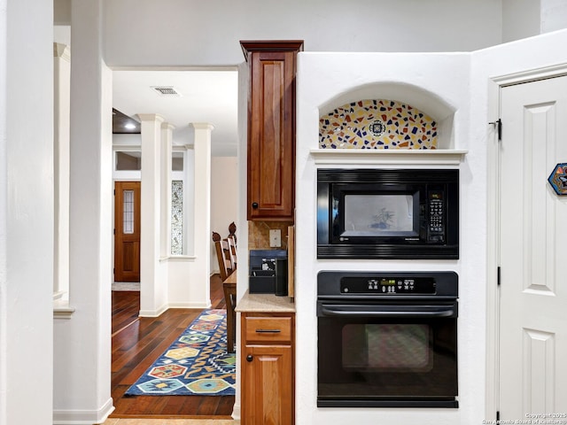 kitchen featuring baseboards, visible vents, dark wood-style flooring, black appliances, and brown cabinets