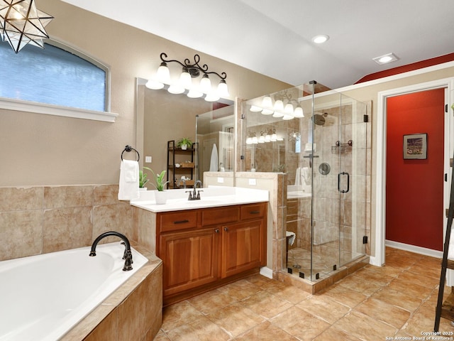 bathroom with lofted ceiling, a garden tub, a stall shower, and vanity