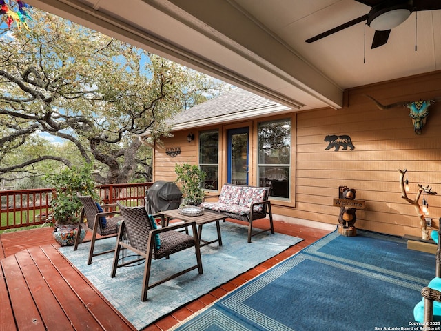 wooden terrace featuring grilling area, an outdoor hangout area, and ceiling fan