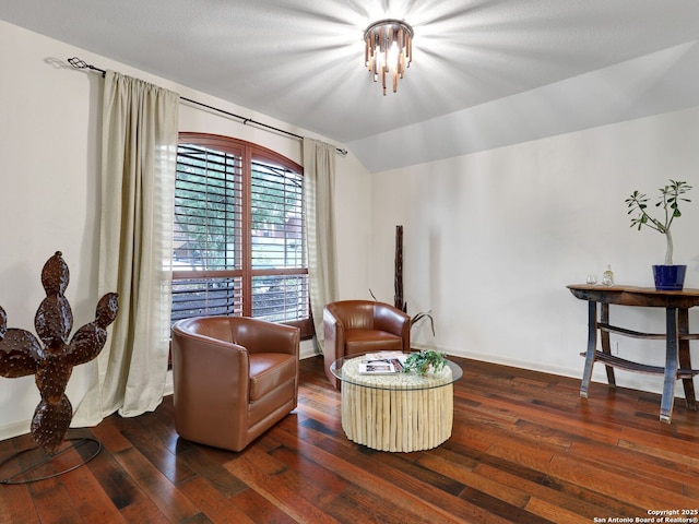 living area featuring vaulted ceiling, baseboards, and wood-type flooring