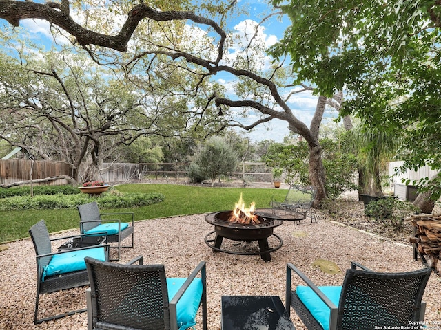 view of yard featuring a patio, a fire pit, and a fenced backyard