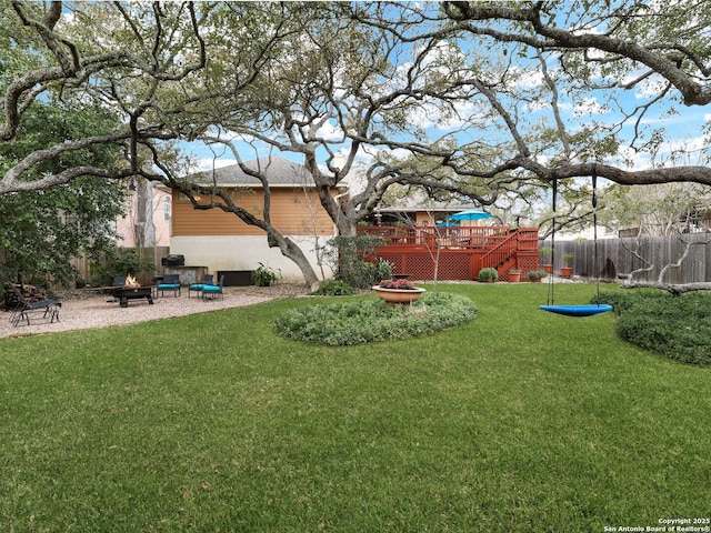 view of yard with a patio, an outdoor fire pit, a deck, and fence