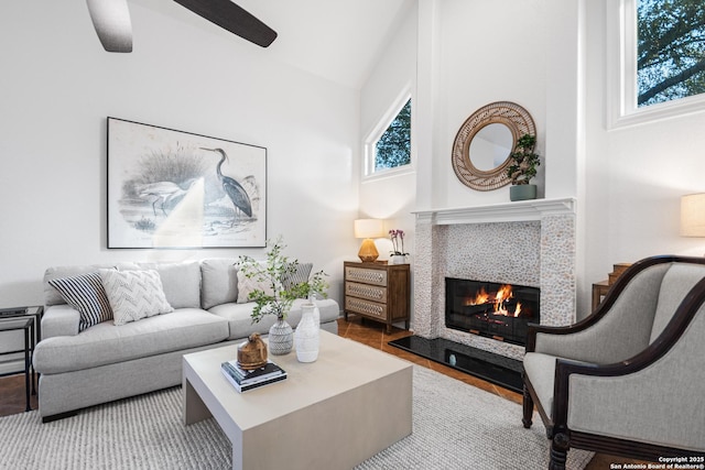 living room featuring a fireplace, a high ceiling, and ceiling fan