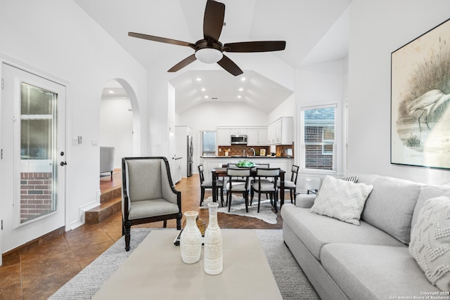 living room featuring dark tile patterned floors, recessed lighting, arched walkways, high vaulted ceiling, and a ceiling fan