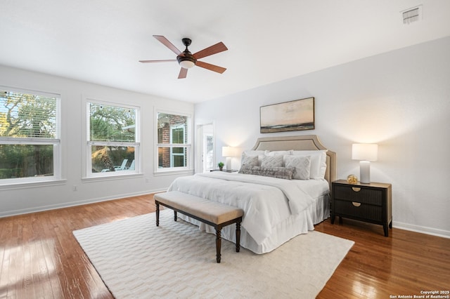 bedroom with visible vents, multiple windows, baseboards, and hardwood / wood-style flooring