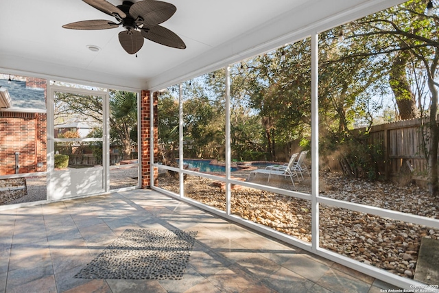 unfurnished sunroom featuring ceiling fan