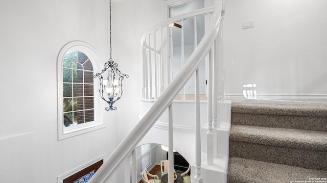 staircase with a chandelier