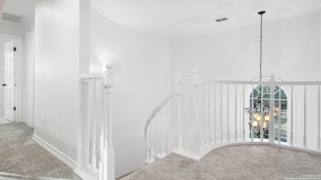 stairway with visible vents and carpet flooring