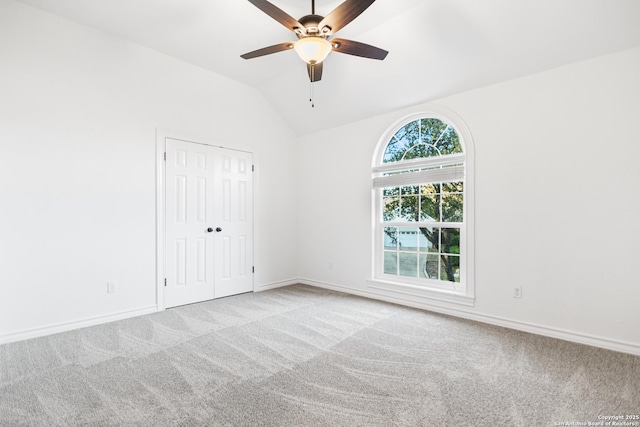 unfurnished room featuring light colored carpet, baseboards, and vaulted ceiling