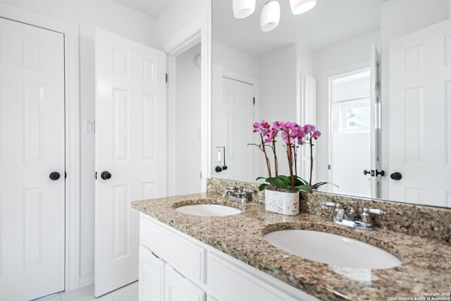 bathroom with a sink, double vanity, and tile patterned flooring