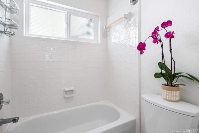 full bathroom featuring toilet,  shower combination, and a textured wall