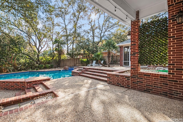 view of pool featuring a pool with connected hot tub, a fenced backyard, and a patio area