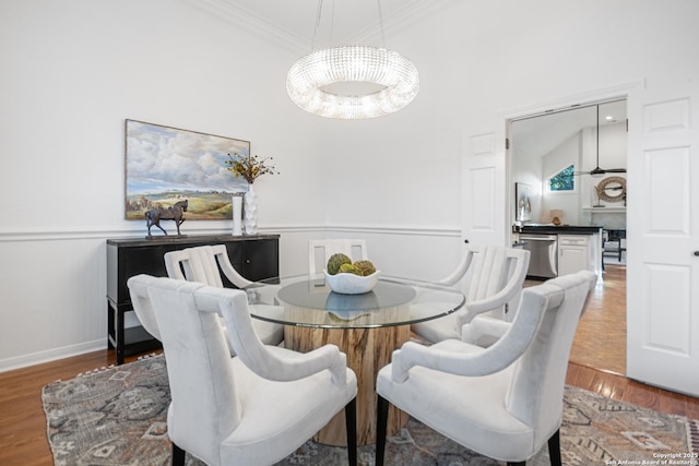 dining space with wood finished floors and crown molding