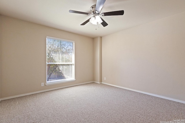 carpeted empty room with ceiling fan and baseboards