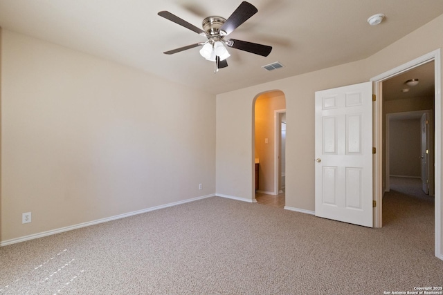 unfurnished bedroom with a ceiling fan, visible vents, baseboards, arched walkways, and carpet flooring