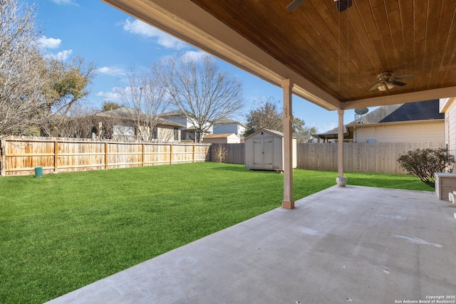 view of yard with a patio, a ceiling fan, a shed, a fenced backyard, and an outdoor structure