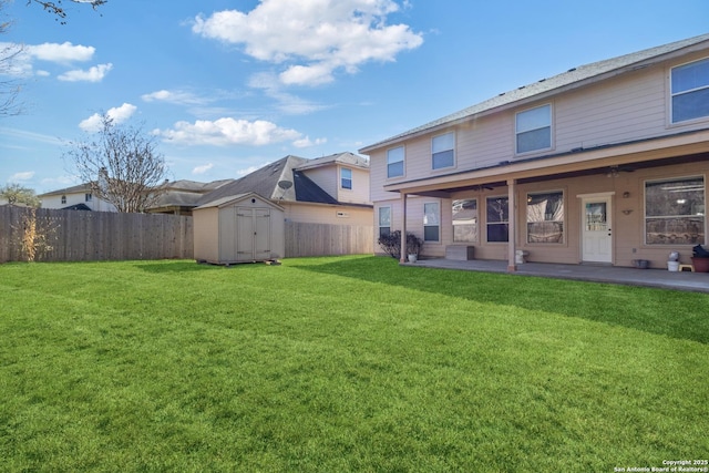 back of house with a shed, a yard, a fenced backyard, an outbuilding, and a patio