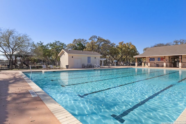 community pool with a patio area and fence