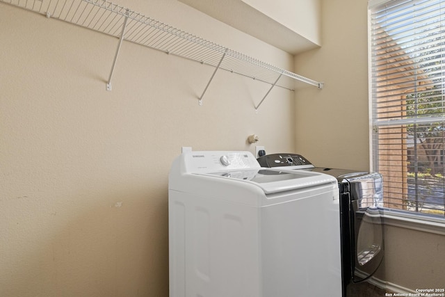 clothes washing area with washing machine and dryer and laundry area