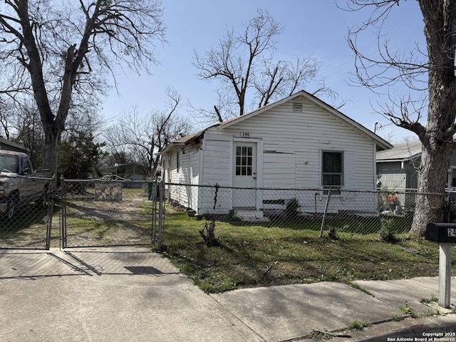 view of side of property featuring a fenced front yard and a gate