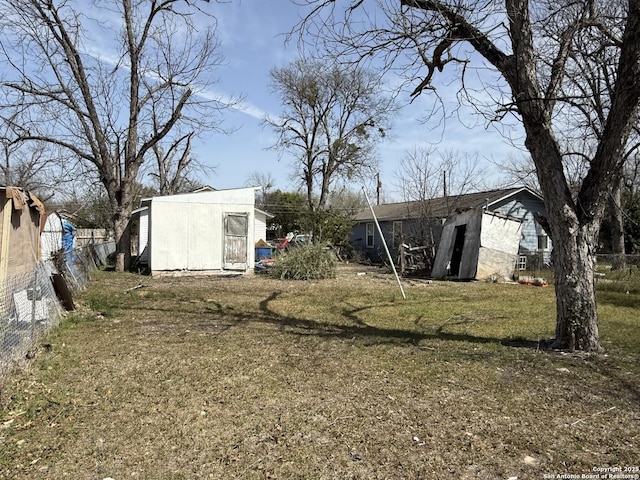 view of yard featuring an outdoor structure and fence