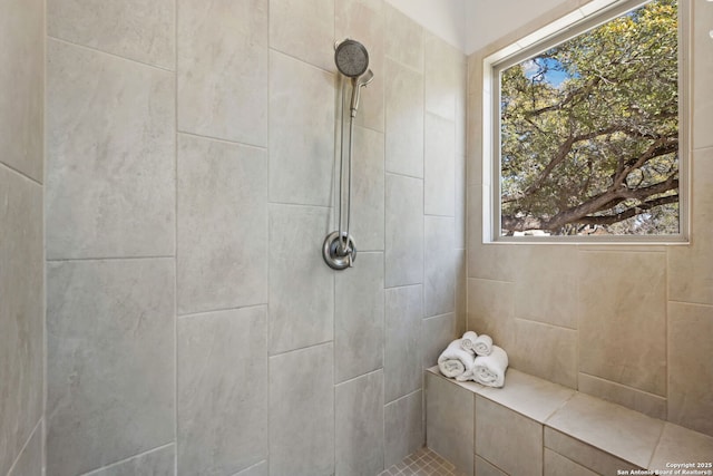 full bathroom featuring plenty of natural light and tiled shower